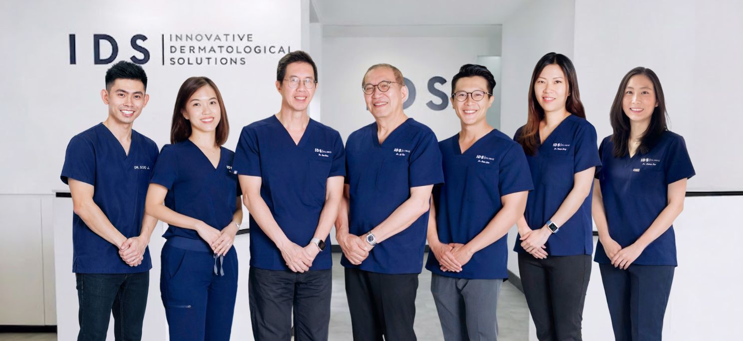 Group of medical professionals in uniforms standing together inside IDS Clinic.
